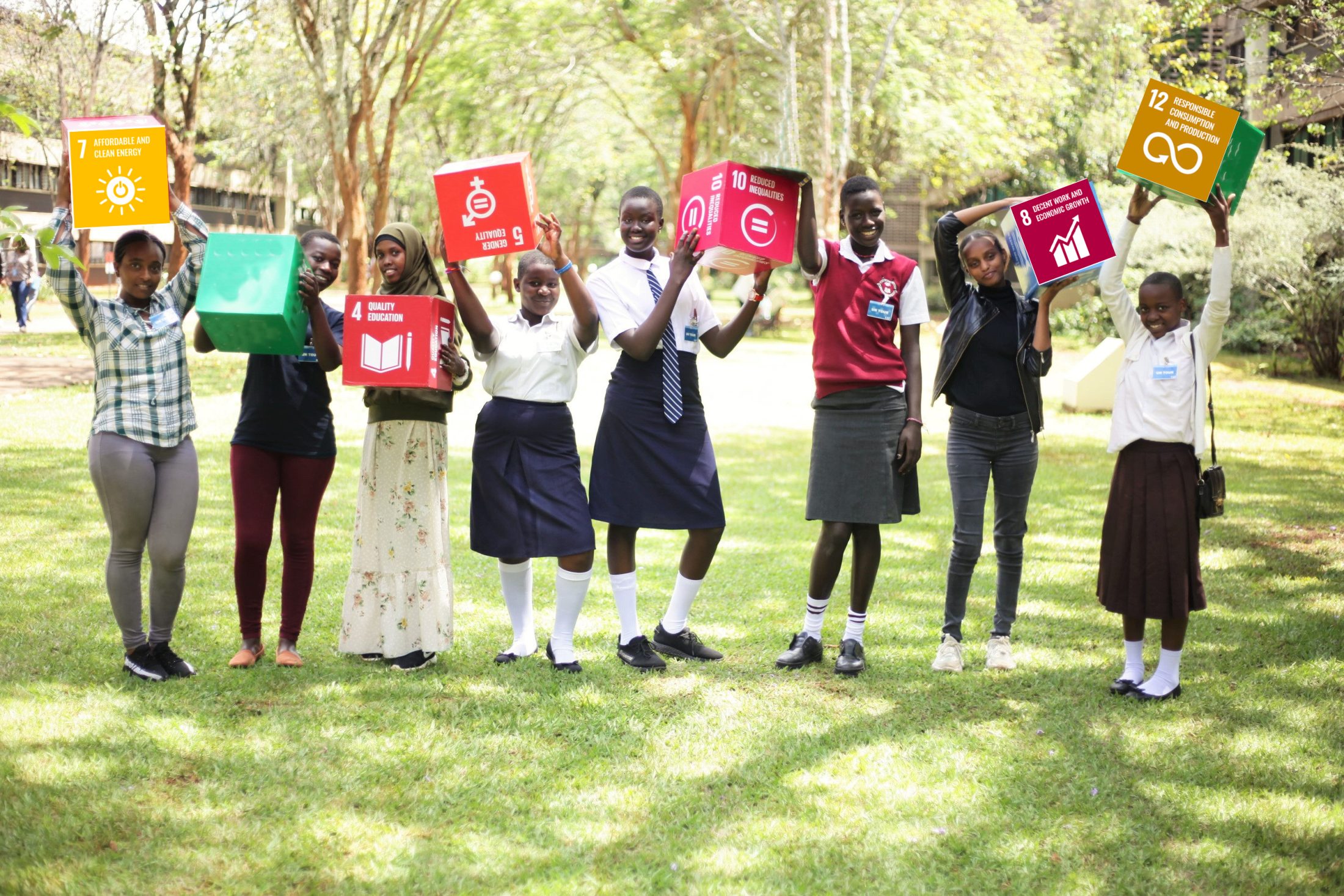 8 girls holding up the signs with ABS Sustainable Development Goals